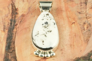 White Buffalo Turquoise set in Sterling Silver Pendant. This Beautiful Stone is formed from the minerals Calcite and Iron. It is mined near Tonopah Nevada. Free 18" Sterling Silver Chain with Purchase of Pendant. Created by Navajo Artist Phillip Sanchez. Signed by the artist.